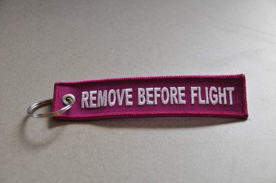 REMOVE BEFORE FLIGHT keychain keyring (pink + white letters)